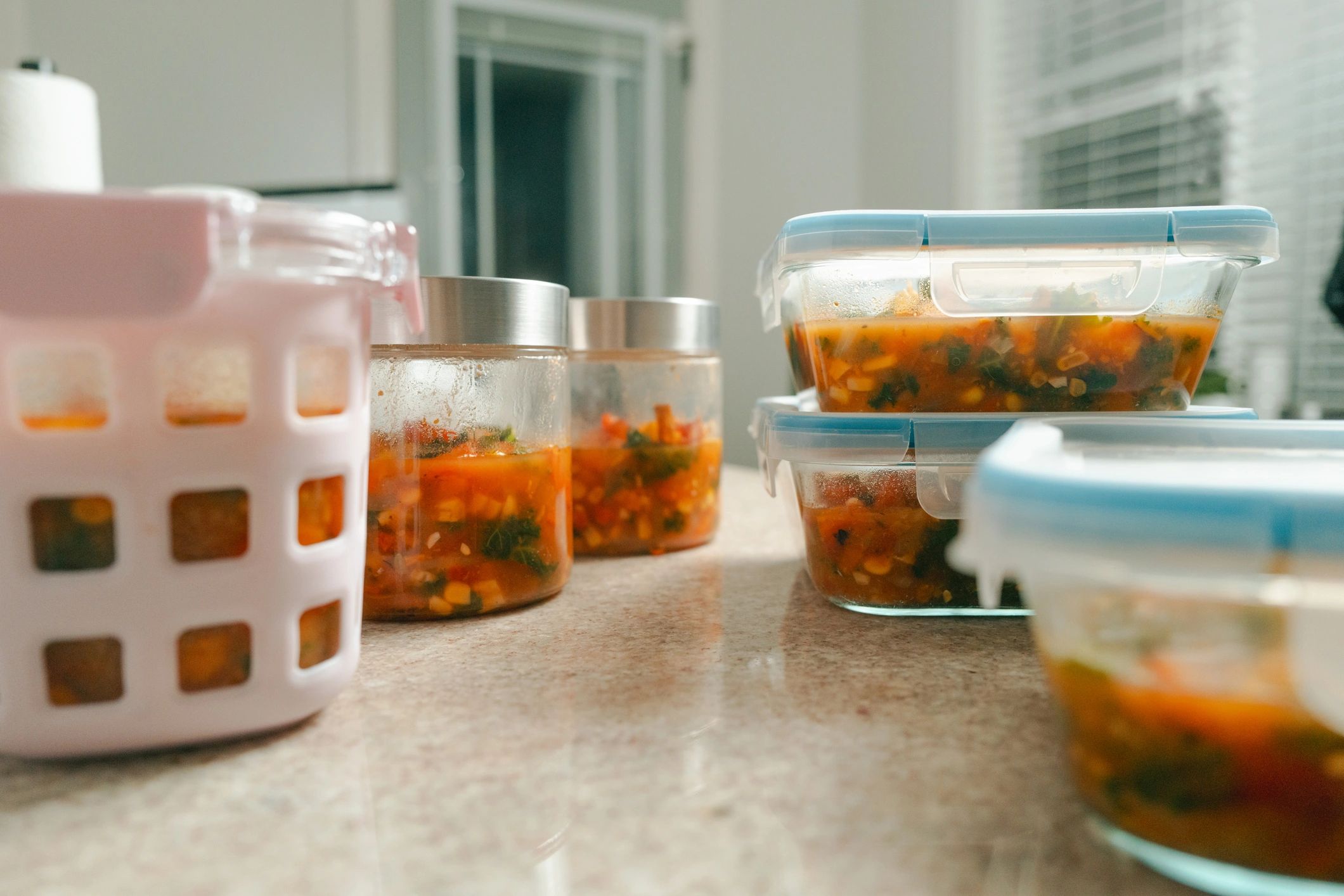 Meal prep containers filled with nourishing soup