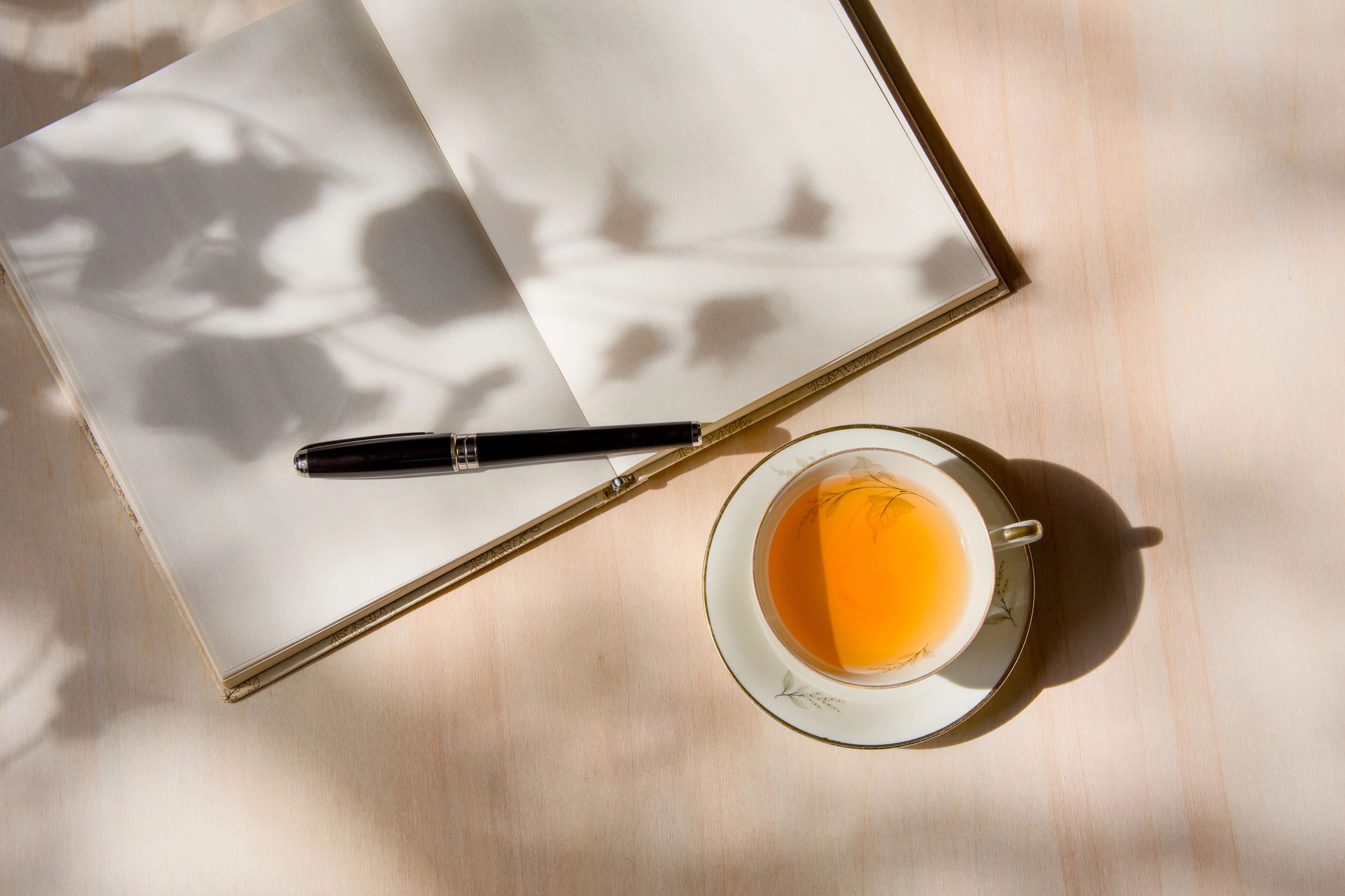 Tea and journal on a sunlit table